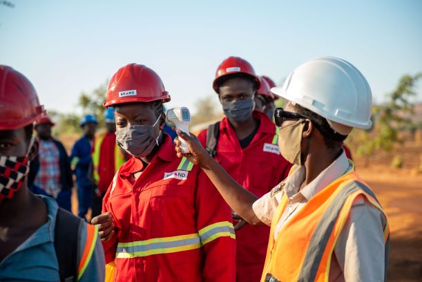 Workers in PPE getting their vitals checked