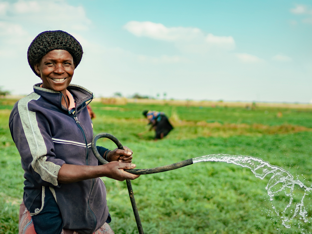 Person holding water hose and smiling