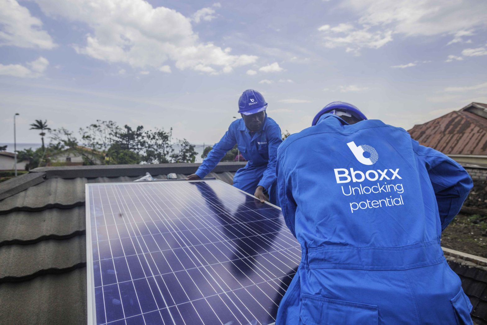 Two Engineers in PPE branded Bboxx working on solar panels